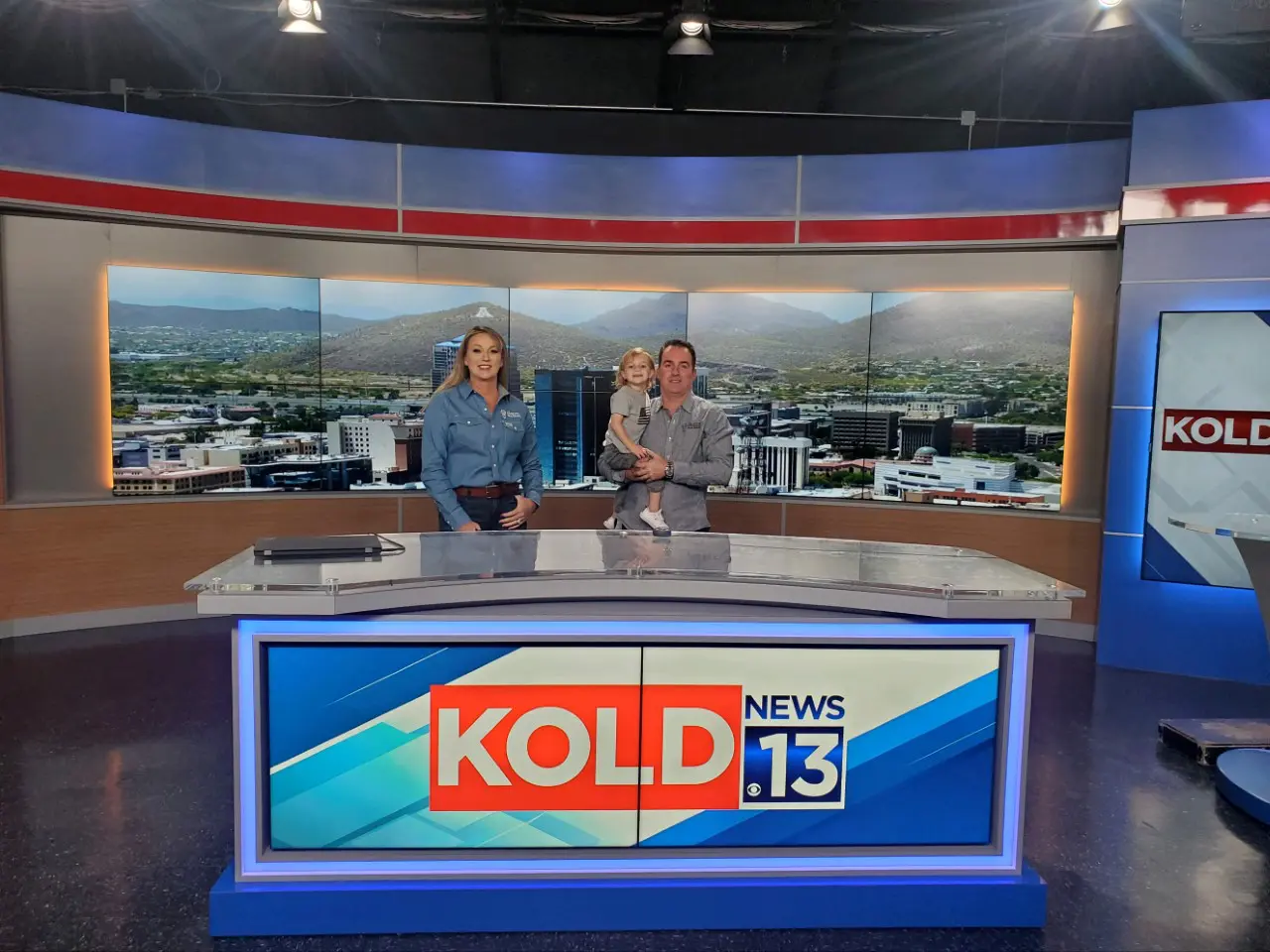 Two people are sitting in a news studio.